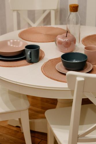 a white table with plates and bowls on it at Staszica16 in Złoty Stok