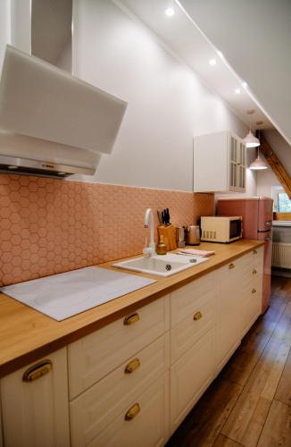 a kitchen with white cabinets and a sink at Staszica16 in Złoty Stok