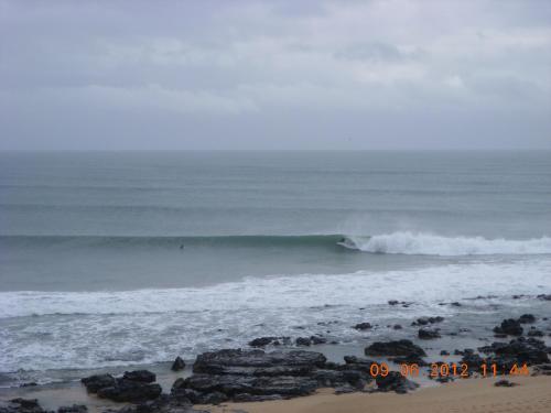 a wave in the ocean on a beach at At the Beach in Jeffreys Bay