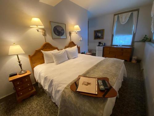 a hotel room with a bed and a tray with a book on it at Chambery Inn in Lee