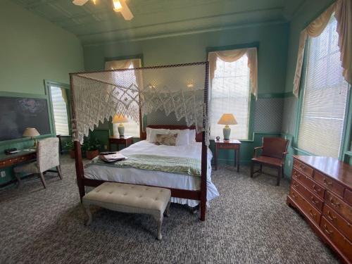 a bedroom with a canopy bed and a desk at Chambery Inn in Lee