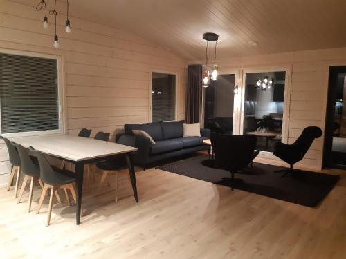 a living room with a couch and a table and chairs at Louhi A in Äkäslompolo