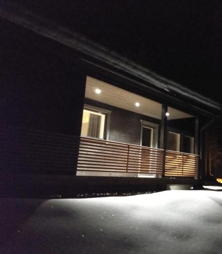 a house at night with a wooden porch at Louhi A in Äkäslompolo