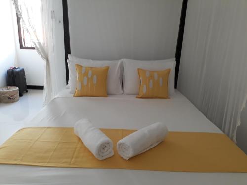 a white bed with two towels on it at Apna Homestay Apartments in Unawatuna