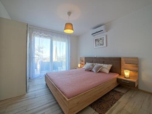 a bedroom with a large bed and a large window at Villa Ketrin in Tinjan