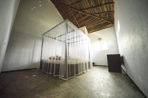 a room with a bed with a net at Mermaid Cabana and Tree Houses in Tangalle