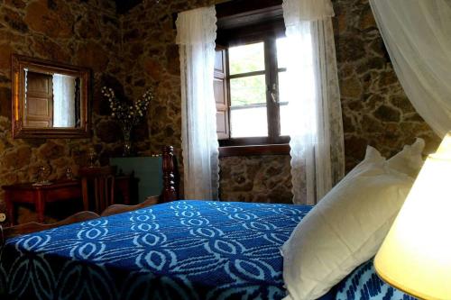 um quarto com uma cama azul e uma janela em CASA MARY LOLA em Tiñor