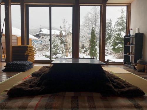 a living room with a glass table in front of a window at yuzaka - natural & sustainable inn - in Kazuno