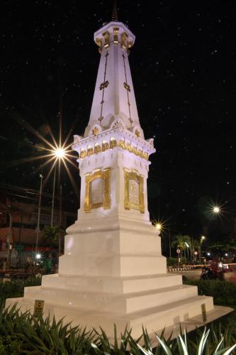 a large white tower with a clock at night at Griya Suryo Wijilan in Yogyakarta