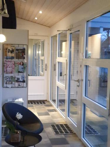 Zimmer mit einer Tür und einem Stuhl neben einem Fenster in der Unterkunft Bente's Guesthouse in Holstebro