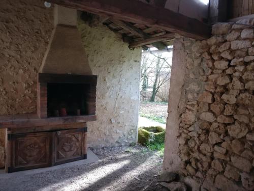 a room with a stone wall with a fireplace at la petite peysie in Lisle