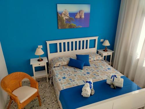 een blauwe slaapkamer met een bed en een stoel bij B&B Il Vialetto in Castellammare di Stabia