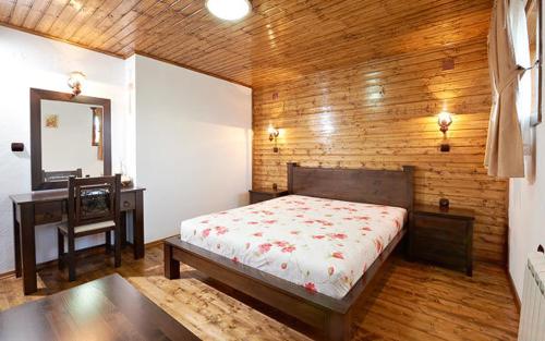 a bedroom with a bed and a desk in it at Complex Staro Bardo in Zheravna
