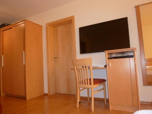 a room with a desk and a chair and a television at Abanico Ferien in Samnaun