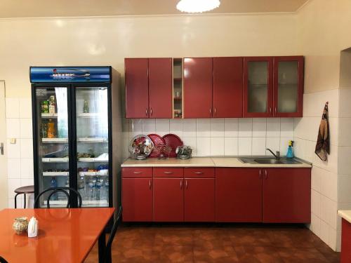 cocina con armarios rojos y nevera en Comfort Hotel, en Chervonograd