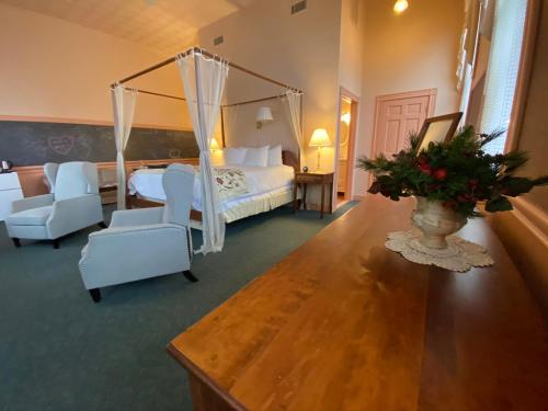 a bedroom with a canopy bed and a living room at Chambery Inn in Lee