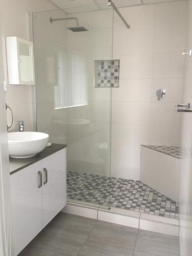 uma casa de banho com um chuveiro, um lavatório e um WC. em Vue Port em Mossel Bay