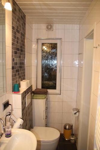 a bathroom with a white toilet and a sink at Ferienwohnung Am Heidelberg in Blankenburg