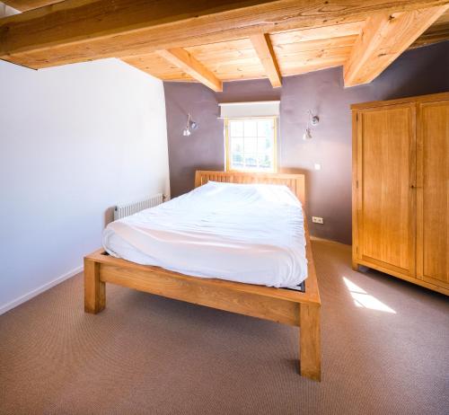 a bedroom with a bed and a wooden cabinet at Molen Hunsingo in Onderdendam