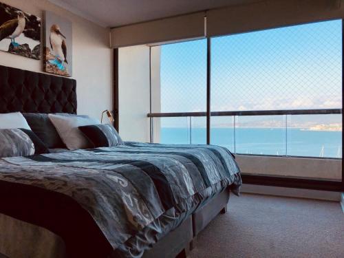 1 dormitorio con cama y ventana grande en Hermoso departamento con increíble vista!, en Concón