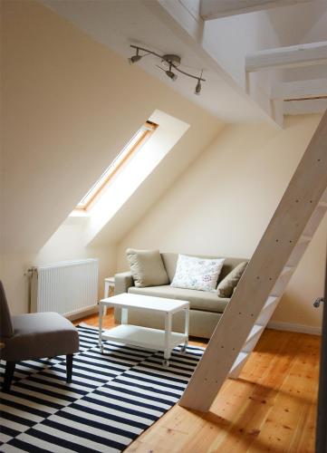 a living room with a couch and a skylight at Gutshof Rothensande in Waabs