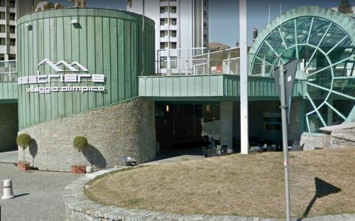 a large green building with a sign on it at Teleo Vacanze - Villaggio Olimpico di Sestriere in Sestriere