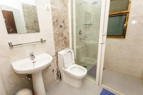 a bathroom with a toilet and a sink and a shower at Feel Like Home Nepal in Kathmandu