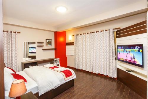 a bedroom with a large bed and a television at Feel Like Home Nepal in Kathmandu