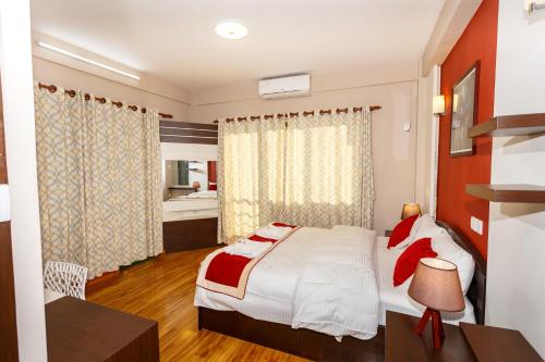 a bedroom with a bed and a desk in a room at Feel Like Home Nepal in Kathmandu
