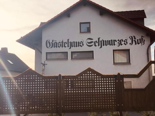 a white house with a sign on the side of it at Landgasthof "Zum Schwarzen Roß" in Eichenzell