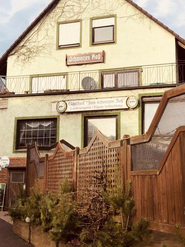 an old building with a fence in front of it at Landgasthof "Zum Schwarzen Roß" in Eichenzell