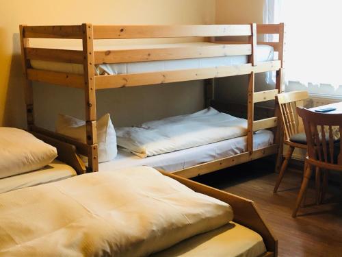 2 Etagenbetten in einem Zimmer mit einem Tisch und Stühlen in der Unterkunft Landgasthof "Zum Schwarzen Roß" in Eichenzell
