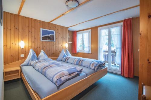 um quarto com uma cama grande com almofadas em Chalet Alpenruh em Saas-Fee