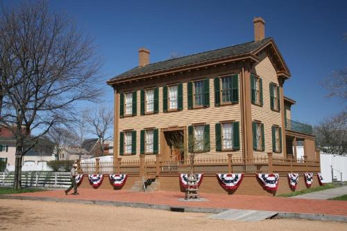 a woman walking in front of a house with flags on it at Inn at 835 Boutique Hotel in Springfield