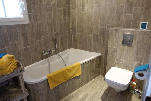 een badkamer met een bad en een toilet bij La Fompatoise in Vérines