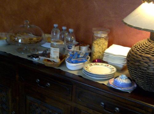 a table with plates and bottles on top at B&B A Casa di Mael in San Costanzo