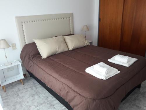 Un dormitorio con una cama con dos toallas encima. en CENTRO NORTE I con cochera incluida, en Bahía Blanca