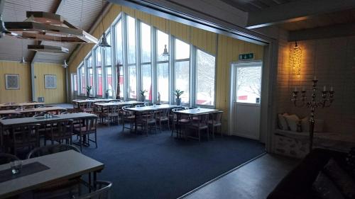 a dining room with tables and chairs and windows at Bollegården B&B in Bollnäs
