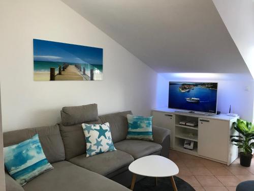 a living room with a couch and a flat screen tv at Uphill Opatija Apartment in Opatija