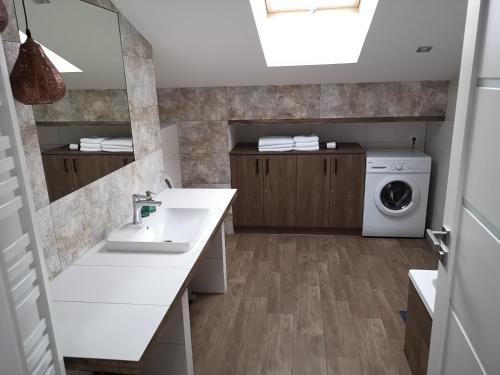 łazienka z umywalką i pralką w obiekcie Apartamenty Rynek we Wrześni