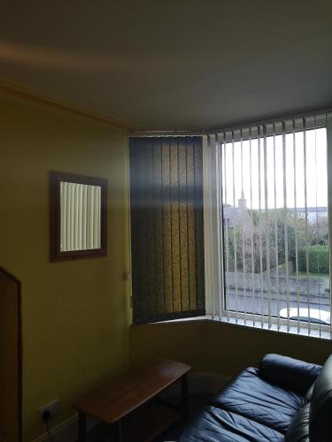 a room with a window with a bed and a table at Granville Guest House in Dyce