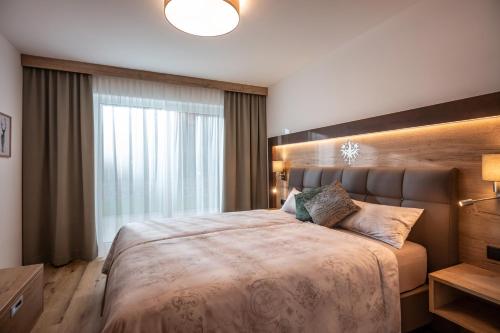 a bedroom with a large bed and a large window at APART deluxe am Wilden Kaiser in Söll