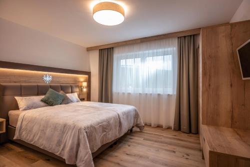 a bedroom with a large bed and a window at APART deluxe am Wilden Kaiser in Söll