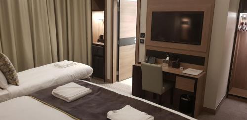 Ένα ή περισσότερα κρεβάτια σε δωμάτιο στο Merit Kensington Hotel