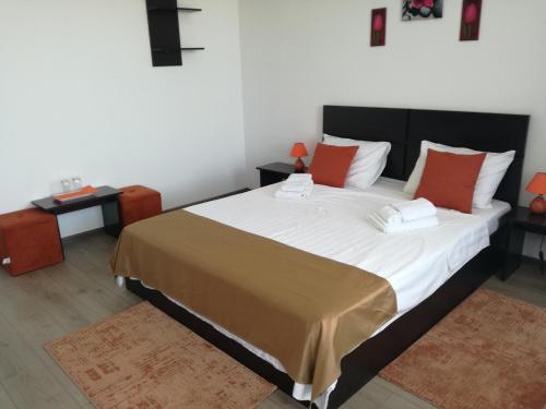 una camera da letto con un grande letto con cuscini rossi di Stella Maris a Techirghiol
