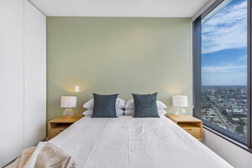 a bedroom with a large bed with a large window at Atop the Melbourne CBD with Panoramic Views DUPLICATE in Melbourne