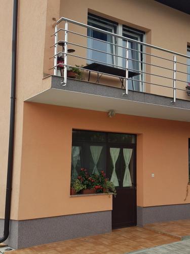 un edificio con balcone e porta con fiori di STUDIO APARTMAN MARIA a Čavle