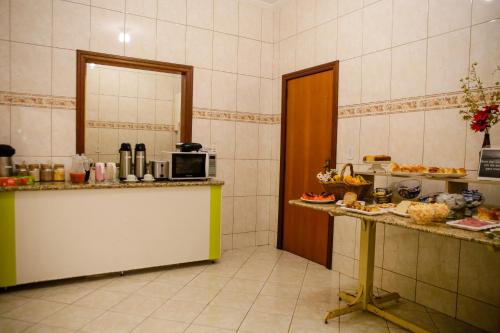 a kitchen with a counter and a microwave at Pousada Santa Cruz in Aparecida
