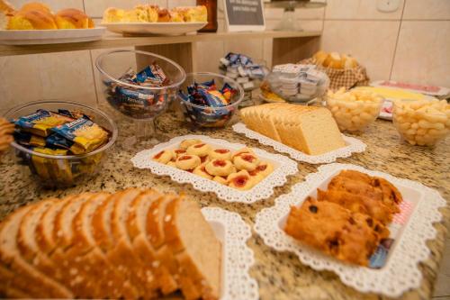 un mostrador con varios pasteles y otros alimentos en él en Pousada Santa Cruz, en Aparecida