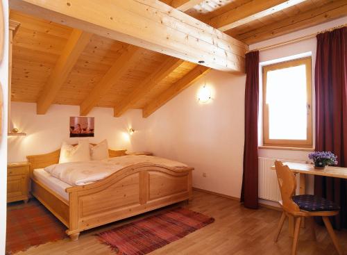 um quarto com uma cama de madeira e uma janela em Fassnauerhof Ridnaun em Racines